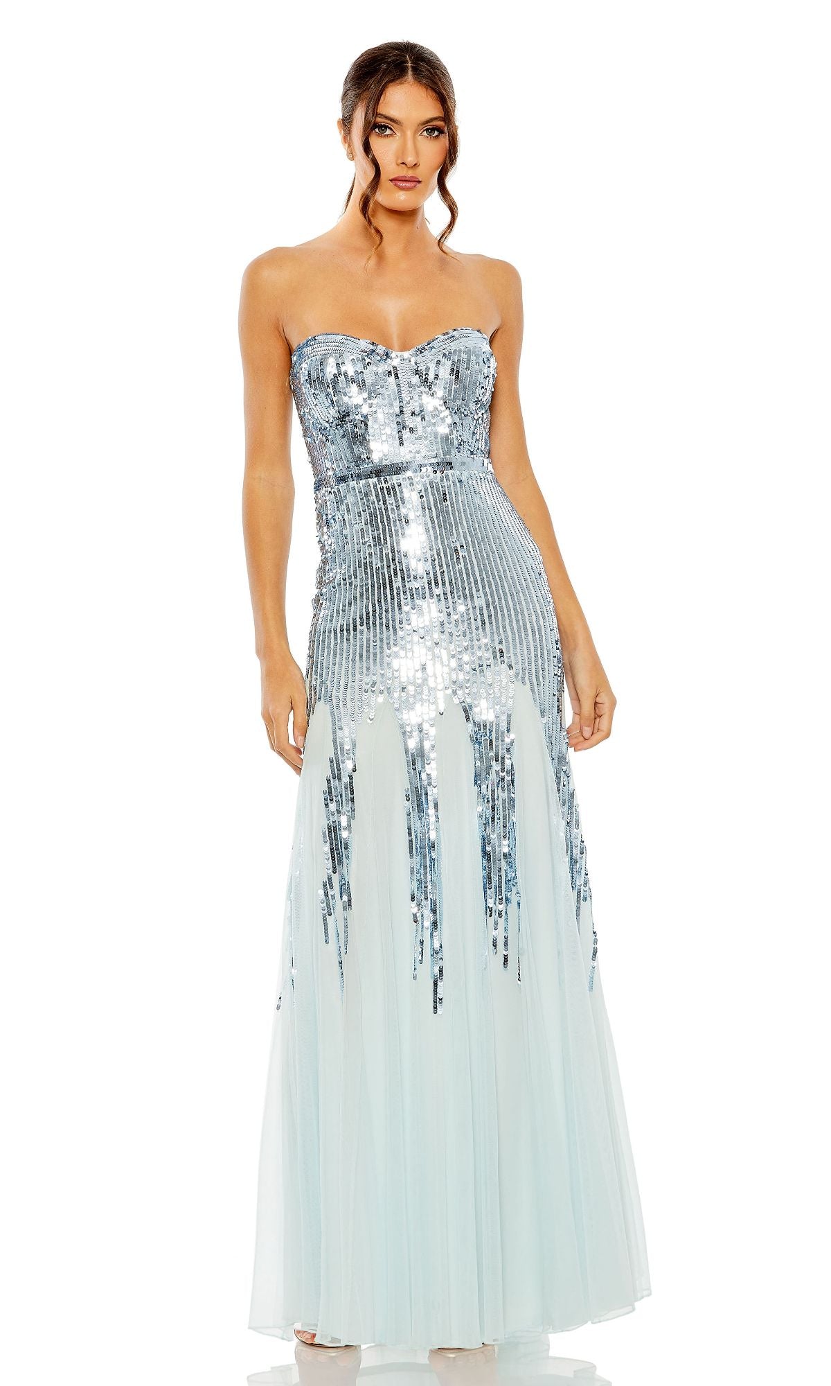 A woman stands facing forward against a white background wearing the Mac Duggal 93959 Strapless Sequin Formal Dress featuring silver sequins and light blue tulle, floor-length.